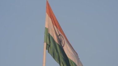 India flag flying high at Connaught Place with pride in blue sky, India flag fluttering, Indian Flag on Independence Day and Republic Day of India, tilt up shot, Waving Indian flag, Har Ghar Tiranga