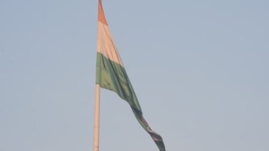 India flag flying high at Connaught Place with pride in blue sky, India flag fluttering, Indian Flag on Independence Day and Republic Day of India, tilt up shot, Waving Indian flag, Har Ghar Tiranga