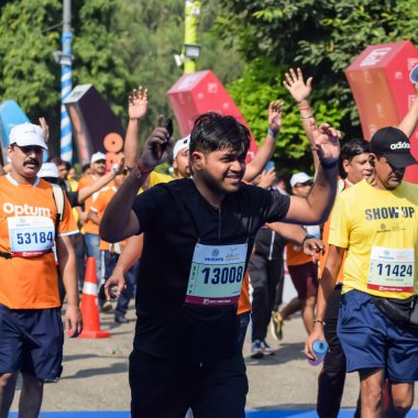 Yeni Delhi, Hindistan - 15 Ekim 2023 - Bitmek üzere olan maraton katılımcılarının bitiş çizgisini geçmek üzere olan Delhi Yarı Maratonu 2023