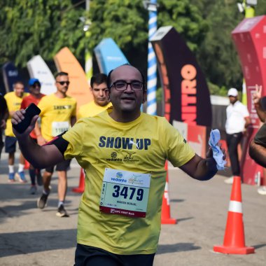 Yeni Delhi, Hindistan - 15 Ekim 2023 - Bitmek üzere olan maraton katılımcılarının bitiş çizgisini geçmek üzere olan Delhi Yarı Maratonu 2023