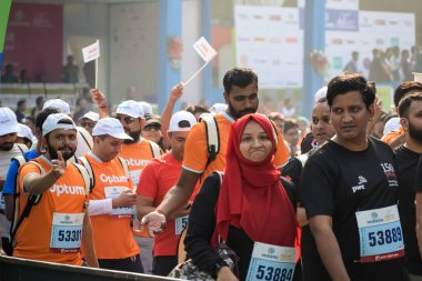 Yeni Delhi, Hindistan - 15 Ekim 2023 - Bitmek üzere olan maraton katılımcılarının bitiş çizgisini geçmek üzere olan Delhi Yarı Maratonu 2023