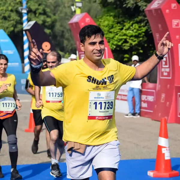 Yeni Delhi, Hindistan - 15 Ekim 2023 - Bitmek üzere olan maraton katılımcılarının bitiş çizgisini geçmek üzere olan Delhi Yarı Maratonu 2023