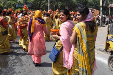 Yeni Delhi, Hindistan 25 Temmuz 2024 - Jagannath Tapınağı sırasında Kalaşlı kadınlar Mangal Kalash Yatra, Hintli Hintli dindarlar üzerinde hindistancevizi olan toprak kapları taşıyorlar