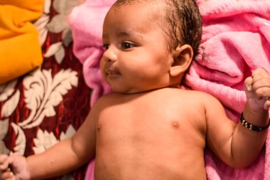 10 aylık sevimli Hintli çocuk evde annesine yağ masajı yapıyor, küçük tatlı çocuk yağ masajının tadını çıkarıyor, küçük çocuk annesinin sağlıklı masajının keyfini çıkarıyor.