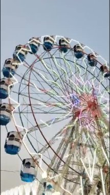 Delhi, Hindistan 'da Dussehra Mela sırasında çok renkli Dev Tekerlek' in yakın çekimi. Dev tekerlek salıncağının alt görüntüsü. Gündüz vakti renkli kamaralı dönme dolap.