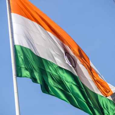 India flag flying high at Connaught Place with pride in blue sky, India flag fluttering, Indian Flag on Independence Day and Republic Day of India, tilt up shot, Waving Indian flag, Har Ghar Tiranga