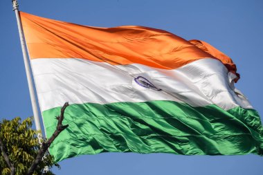 India flag flying high at Connaught Place with pride in blue sky, India flag fluttering, Indian Flag on Independence Day and Republic Day of India, tilt up shot, Waving Indian flag, Har Ghar Tiranga