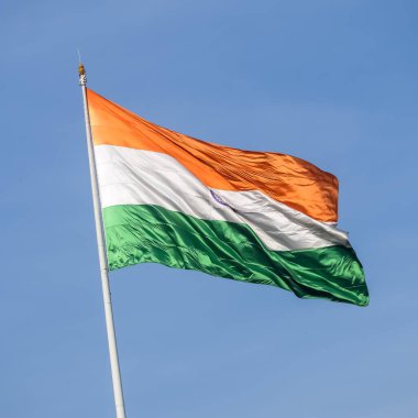 India flag flying high at Connaught Place with pride in blue sky, India flag fluttering, Indian Flag on Independence Day and Republic Day of India, tilt up shot, Waving Indian flag, Har Ghar Tiranga