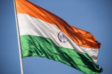 India flag flying high at Connaught Place with pride in blue sky, India flag fluttering, Indian Flag on Independence Day and Republic Day of India, tilt up shot, Waving Indian flag, Har Ghar Tiranga