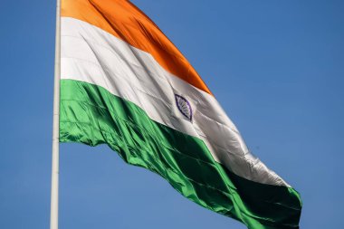 India flag flying high at Connaught Place with pride in blue sky, India flag fluttering, Indian Flag on Independence Day and Republic Day of India, tilt up shot, Waving Indian flag, Har Ghar Tiranga