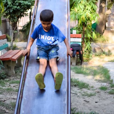 Asyalı çocuk sabah vakti sosyete parkında rutin egzersiz yapıyor. Kendini hayat boyu zinde tutmak için şirin bir çocuk egzersizi ve spor salonu. Açık havada çocuk egzersizi.