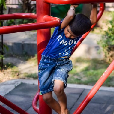 Asyalı çocuk sabah vakti sosyete parkında rutin egzersiz yapıyor. Kendini hayat boyu zinde tutmak için şirin bir çocuk egzersizi ve spor salonu. Açık havada çocuk egzersizi.