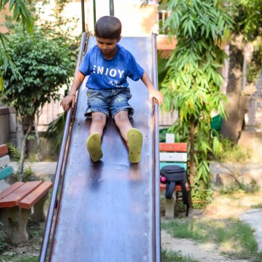 Asyalı çocuk sabah vakti sosyete parkında rutin egzersiz yapıyor. Kendini hayat boyu zinde tutmak için şirin bir çocuk egzersizi ve spor salonu. Açık havada çocuk egzersizi.