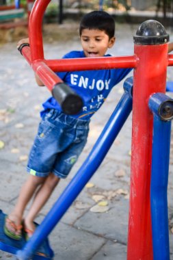 Asyalı çocuk sabah vakti sosyete parkında rutin egzersiz yapıyor. Kendini hayat boyu zinde tutmak için şirin bir çocuk egzersizi ve spor salonu. Açık havada çocuk egzersizi.