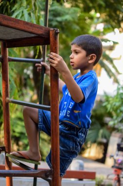 Asyalı çocuk sabah vakti sosyete parkında rutin egzersiz yapıyor. Kendini hayat boyu zinde tutmak için şirin bir çocuk egzersizi ve spor salonu. Açık havada çocuk egzersizi.