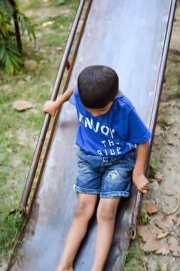 Asyalı çocuk sabah vakti sosyete parkında rutin egzersiz yapıyor. Kendini hayat boyu zinde tutmak için şirin bir çocuk egzersizi ve spor salonu. Açık havada çocuk egzersizi.