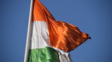 India flag flying high at Connaught Place with pride in blue sky, India flag fluttering, Indian Flag on Independence Day and Republic Day of India, tilt up shot, Waving Indian flag, Har Ghar Tiranga