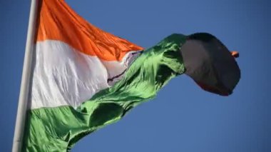 India flag flying high at Connaught Place with pride in blue sky, India flag fluttering, Indian Flag on Independence Day and Republic Day of India, tilt up shot, Waving Indian flag, Har Ghar Tiranga
