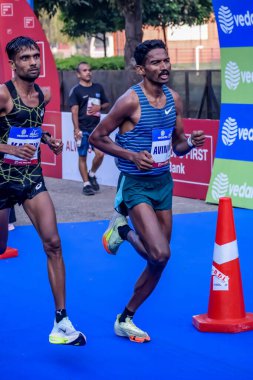 Yeni Delhi, Hindistan - 20 Ekim 2024 - Bitmek üzere olan maraton katılımcılarının bitiş çizgisini geçmek üzere olan Delhi Yarı Maratonu 2024