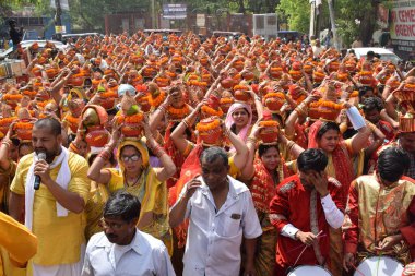 Yeni Delhi, Hindistan 25 Temmuz 2024 - Jagannath Tapınağı sırasında Kalaşlı kadınlar Mangal Kalash Yatra, Hintli Hintli dindarlar üzerinde hindistancevizi olan toprak kapları taşıyorlar