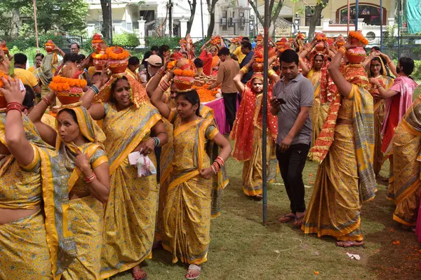 Yeni Delhi, Hindistan 25 Temmuz 2024 - Jagannath Tapınağı sırasında Kalaşlı kadınlar Mangal Kalash Yatra, Hintli Hintli dindarlar üzerinde hindistancevizi olan toprak kapları taşıyorlar