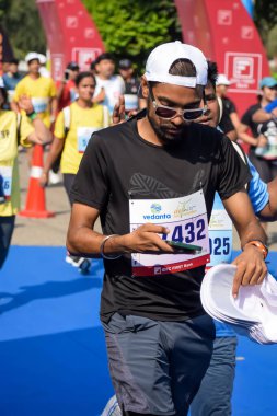 Yeni Delhi, Hindistan - 20 Ekim 2024 - Bitmek üzere olan maraton katılımcılarının bitiş çizgisini geçmek üzere olan Delhi Yarı Maratonu 2024