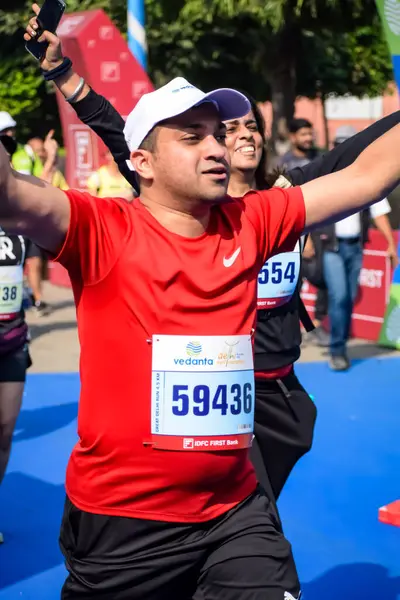 Yeni Delhi, Hindistan - 20 Ekim 2024 - Bitmek üzere olan maraton katılımcılarının bitiş çizgisini geçmek üzere olan Delhi Yarı Maratonu 2024