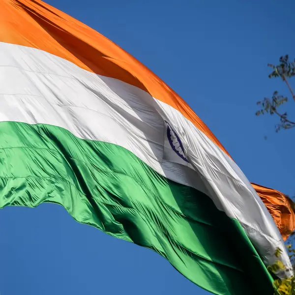 India flag flying high at Connaught Place with pride in blue sky, India flag fluttering, Indian Flag on Independence Day and Republic Day of India, tilt up shot, Waving Indian flag, Har Ghar Tiranga