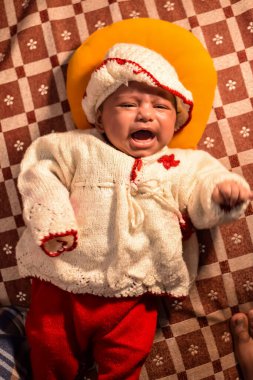 10 aylık sevimli küçük Hintli çocuk evde mutlu anların tadını çıkarıyor, tatlı küçük çocuk evde oynayan ve gülümseyen küçük bebekle eğleniyor.