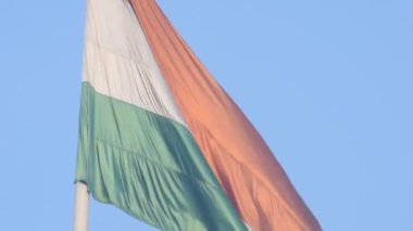 India flag flying high at Connaught Place with pride in blue sky, India flag fluttering, Indian Flag on Independence Day and Republic Day of India, tilt up shot, Waving Indian flag, Har Ghar Tiranga