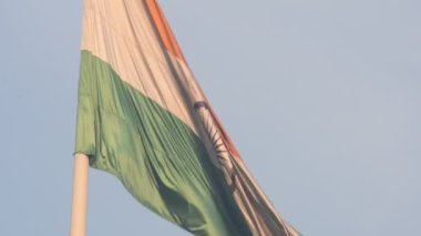India flag flying high at Connaught Place with pride in blue sky, India flag fluttering, Indian Flag on Independence Day and Republic Day of India, tilt up shot, Waving Indian flag, Har Ghar Tiranga