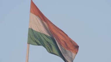 India flag flying high at Connaught Place with pride in blue sky, India flag fluttering, Indian Flag on Independence Day and Republic Day of India, tilt up shot, Waving Indian flag, Har Ghar Tiranga