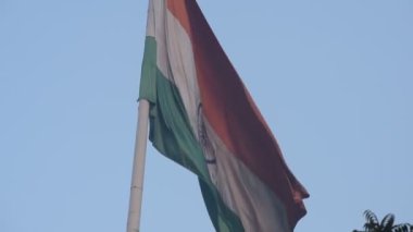 India flag flying high at Connaught Place with pride in blue sky, India flag fluttering, Indian Flag on Independence Day and Republic Day of India, tilt up shot, Waving Indian flag, Har Ghar Tiranga