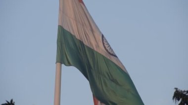 India flag flying high at Connaught Place with pride in blue sky, India flag fluttering, Indian Flag on Independence Day and Republic Day of India, tilt up shot, Waving Indian flag, Har Ghar Tiranga