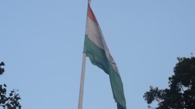 India flag flying high at Connaught Place with pride in blue sky, India flag fluttering, Indian Flag on Independence Day and Republic Day of India, tilt up shot, Waving Indian flag, Har Ghar Tiranga