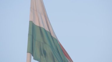 India flag flying high at Connaught Place with pride in blue sky, India flag fluttering, Indian Flag on Independence Day and Republic Day of India, tilt up shot, Waving Indian flag, Har Ghar Tiranga
