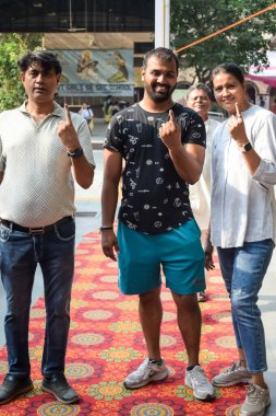 New Delhi, India - May 25 2024 - Unidentified people showing their ink-marked fingers after casting votes in front of polling booth of east Delhi area for general Lok Sabha Elections 2024 clipart