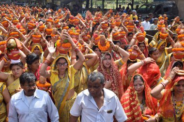 Yeni Delhi, Hindistan 25 Temmuz 2024 - Jagannath Tapınağı sırasında Kalaşlı kadınlar Mangal Kalash Yatra, Hintli Hintli dindarlar üzerinde hindistancevizi olan toprak kapları taşıyorlar