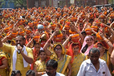 Yeni Delhi, Hindistan 25 Temmuz 2024 - Jagannath Tapınağı sırasında Kalaşlı kadınlar Mangal Kalash Yatra, Hintli Hintli dindarlar üzerinde hindistancevizi olan toprak kapları taşıyorlar