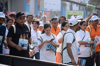 Yeni Delhi, Hindistan - 20 Ekim 2024 - Bitmek üzere olan maraton katılımcılarının bitiş çizgisini geçmek üzere olan Delhi Yarı Maratonu 2024