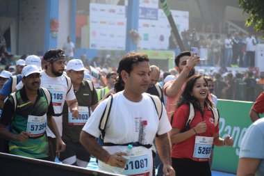 Yeni Delhi, Hindistan - 20 Ekim 2024 - Bitmek üzere olan maraton katılımcılarının bitiş çizgisini geçmek üzere olan Delhi Yarı Maratonu 2024