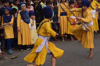 Delhi, Hindistan, 17 Kasım 2024 - Doğu Delhi bölgesinde Guru Nanak Dev, Nagar Kirtan 'ın doğum günü dolayısıyla geleneksel Nagar Kirtan, geleneksel Nagar geçit töreninde Sihler gatka ve dövüş sanatlarını sergiliyor