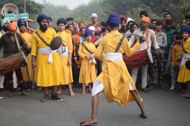 Delhi, Hindistan, 17 Kasım 2024 - Doğu Delhi bölgesinde Guru Nanak Dev, Nagar Kirtan 'ın doğum günü dolayısıyla geleneksel Nagar Kirtan, geleneksel Nagar geçit töreninde Sihler gatka ve dövüş sanatlarını sergiliyor