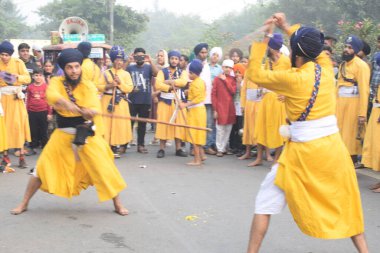 Delhi, Hindistan, 17 Kasım 2024 - Doğu Delhi bölgesinde Guru Nanak Dev, Nagar Kirtan 'ın doğum günü dolayısıyla geleneksel Nagar Kirtan, geleneksel Nagar geçit töreninde Sihler gatka ve dövüş sanatlarını sergiliyor