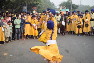 Delhi, Hindistan, 17 Kasım 2024 - Doğu Delhi bölgesinde Guru Nanak Dev, Nagar Kirtan 'ın doğum günü dolayısıyla geleneksel Nagar Kirtan, geleneksel Nagar geçit töreninde Sihler gatka ve dövüş sanatlarını sergiliyor