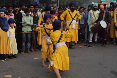 Delhi, Hindistan, 17 Kasım 2024 - Doğu Delhi bölgesinde Guru Nanak Dev, Nagar Kirtan 'ın doğum günü dolayısıyla geleneksel Nagar Kirtan, geleneksel Nagar geçit töreninde Sihler gatka ve dövüş sanatlarını sergiliyor