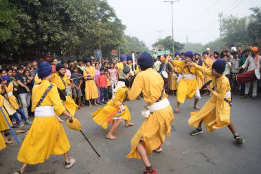 Delhi, Hindistan, 17 Kasım 2024 - Doğu Delhi bölgesinde Guru Nanak Dev, Nagar Kirtan 'ın doğum günü dolayısıyla geleneksel Nagar Kirtan, geleneksel Nagar geçit töreninde Sihler gatka ve dövüş sanatlarını sergiliyor