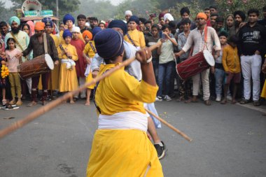 Delhi, Hindistan, 17 Kasım 2024 - Doğu Delhi bölgesinde Guru Nanak Dev, Nagar Kirtan 'ın doğum günü dolayısıyla geleneksel Nagar Kirtan, geleneksel Nagar geçit töreninde Sihler gatka ve dövüş sanatlarını sergiliyor