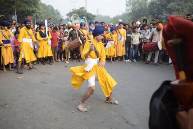 Delhi, Hindistan, 17 Kasım 2024 - Doğu Delhi bölgesinde Guru Nanak Dev, Nagar Kirtan 'ın doğum günü dolayısıyla geleneksel Nagar Kirtan, geleneksel Nagar geçit töreninde Sihler gatka ve dövüş sanatlarını sergiliyor