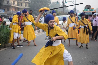 Delhi, Hindistan, 17 Kasım 2024 - Doğu Delhi bölgesinde Guru Nanak Dev, Nagar Kirtan 'ın doğum günü dolayısıyla geleneksel Nagar Kirtan, geleneksel Nagar geçit töreninde Sihler gatka ve dövüş sanatlarını sergiliyor